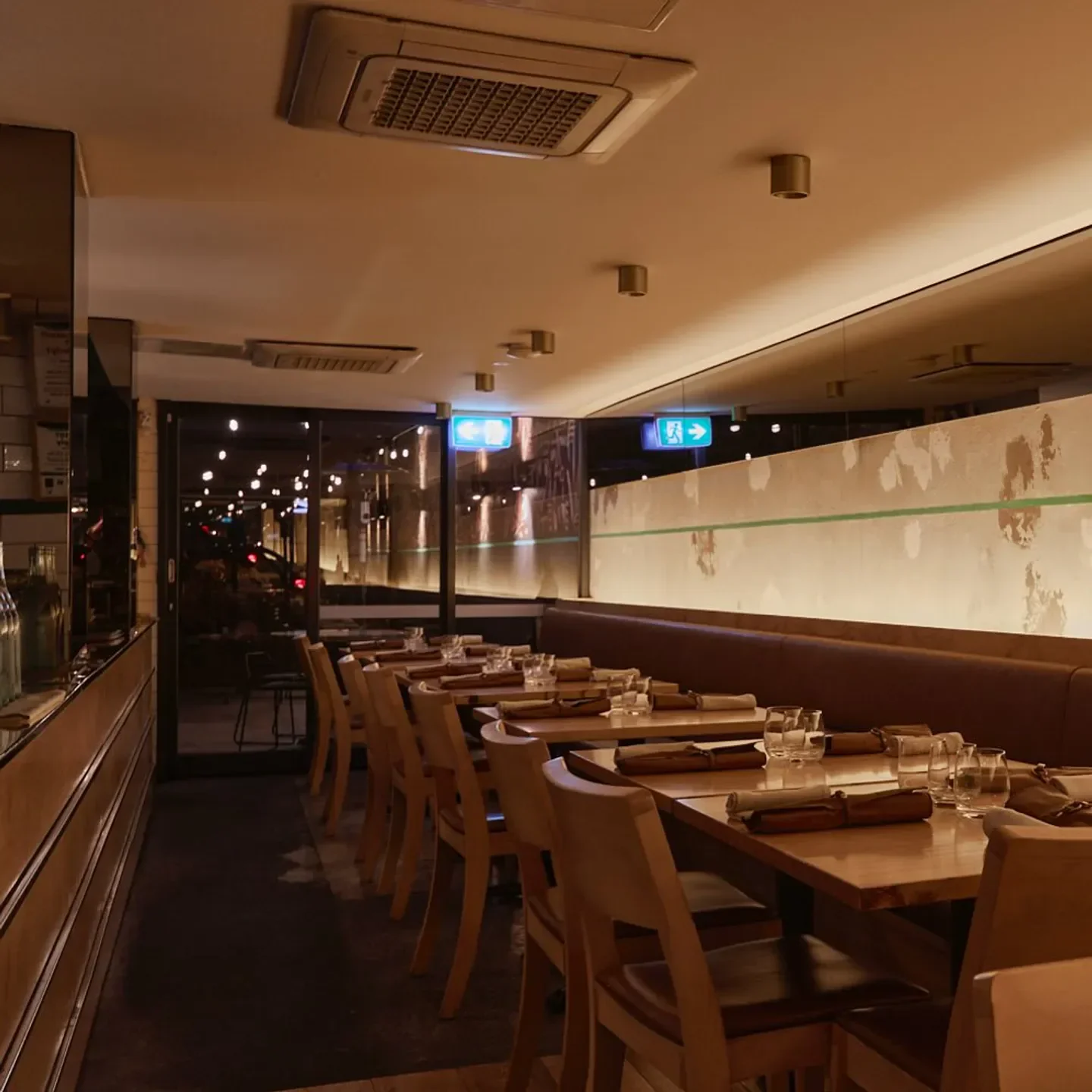 Cozy dining room at Atlas Dining in Melbourne, with tables set for a meal.