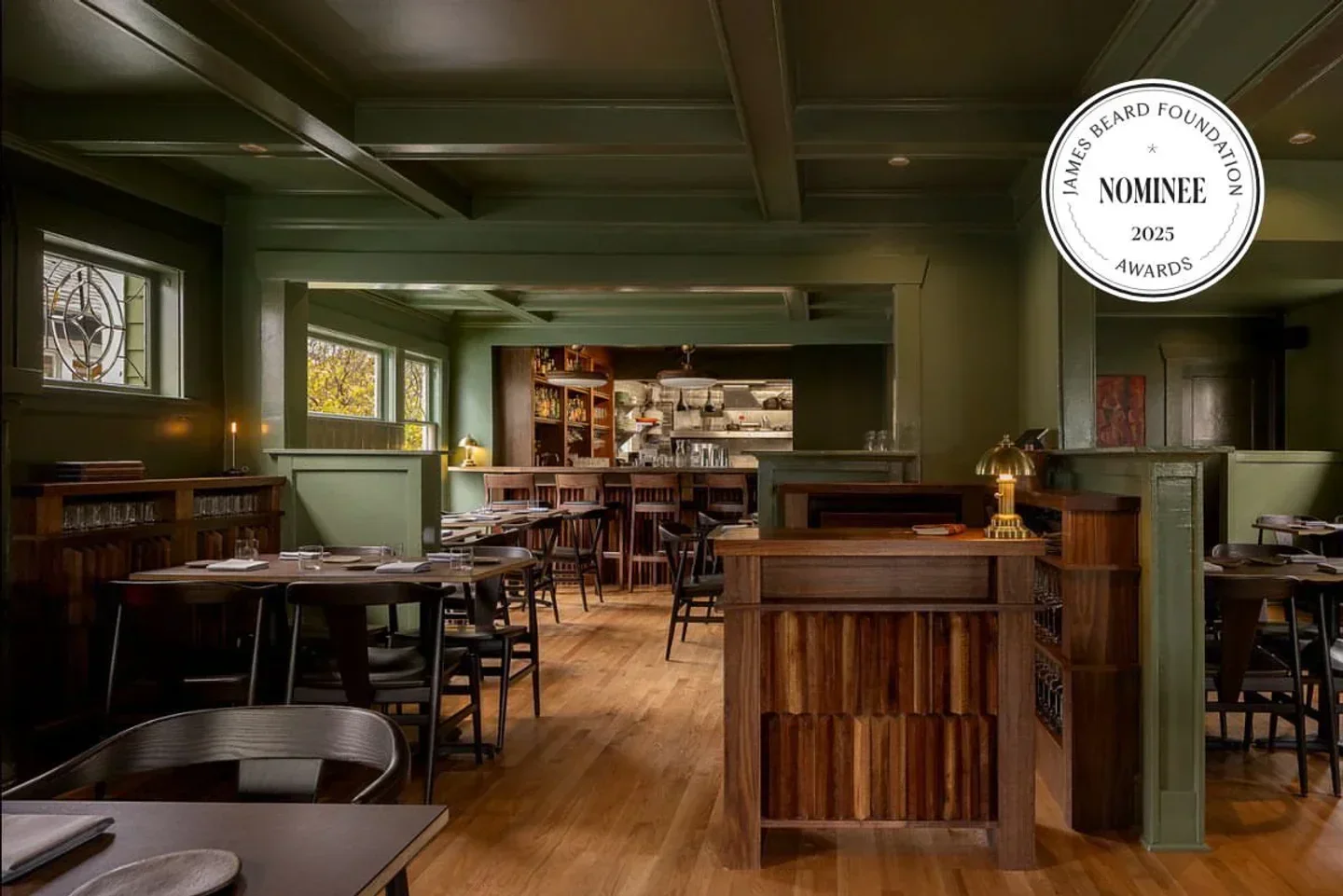 Interior of Atoma restaurant in Seattle, showing dining area and bar with James Beard nominee logo