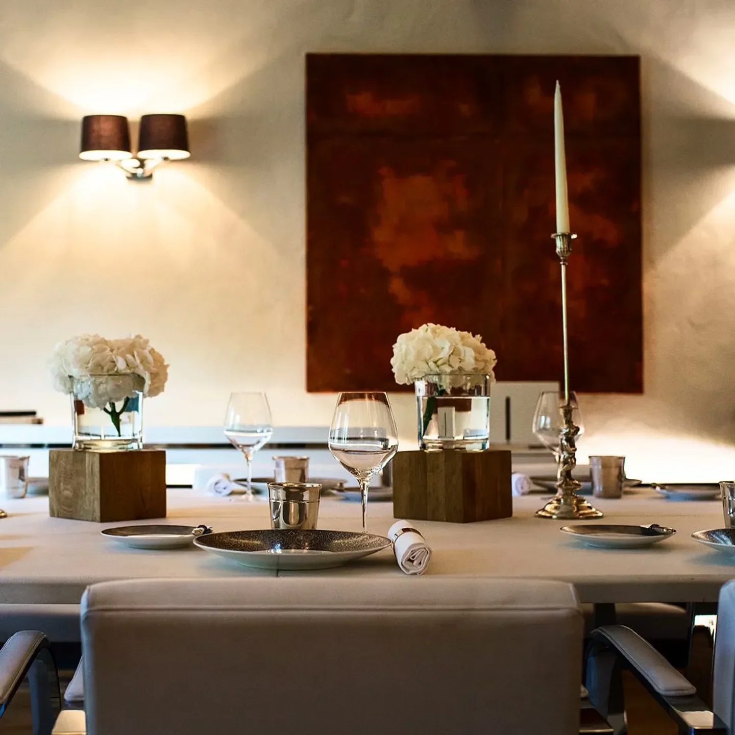 Elegant dining table setting at Auberge de l'Île Barbe restaurant in Lyon with floral centerpieces.