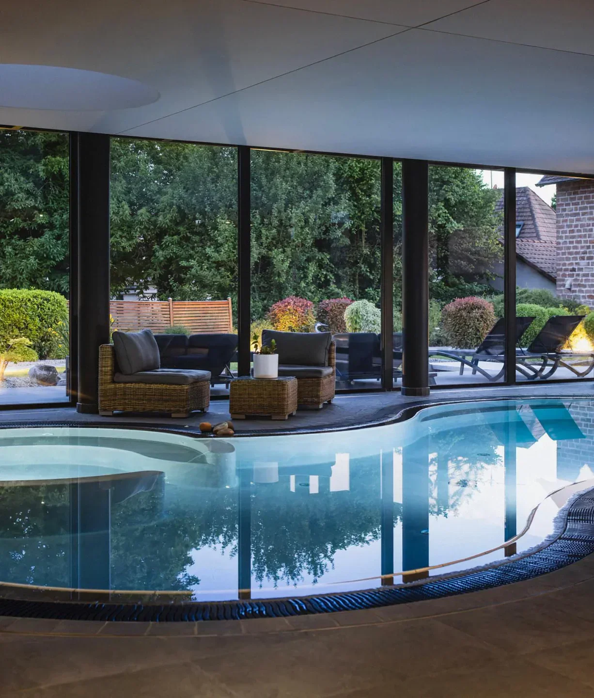 Indoor pool at Auberge du Cheval Blanc in Strasbourg, with lounge chairs and garden view.