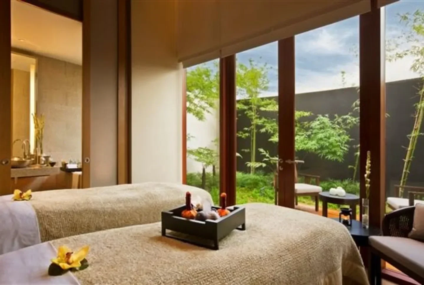 Relaxing spa treatment room at Auriga Spa at Capella Singapore, overlooking garden.
