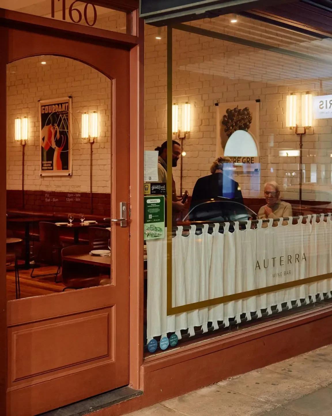 Exterior view of Auterra Wine Bar in Melbourne, showcasing the interior through the window.