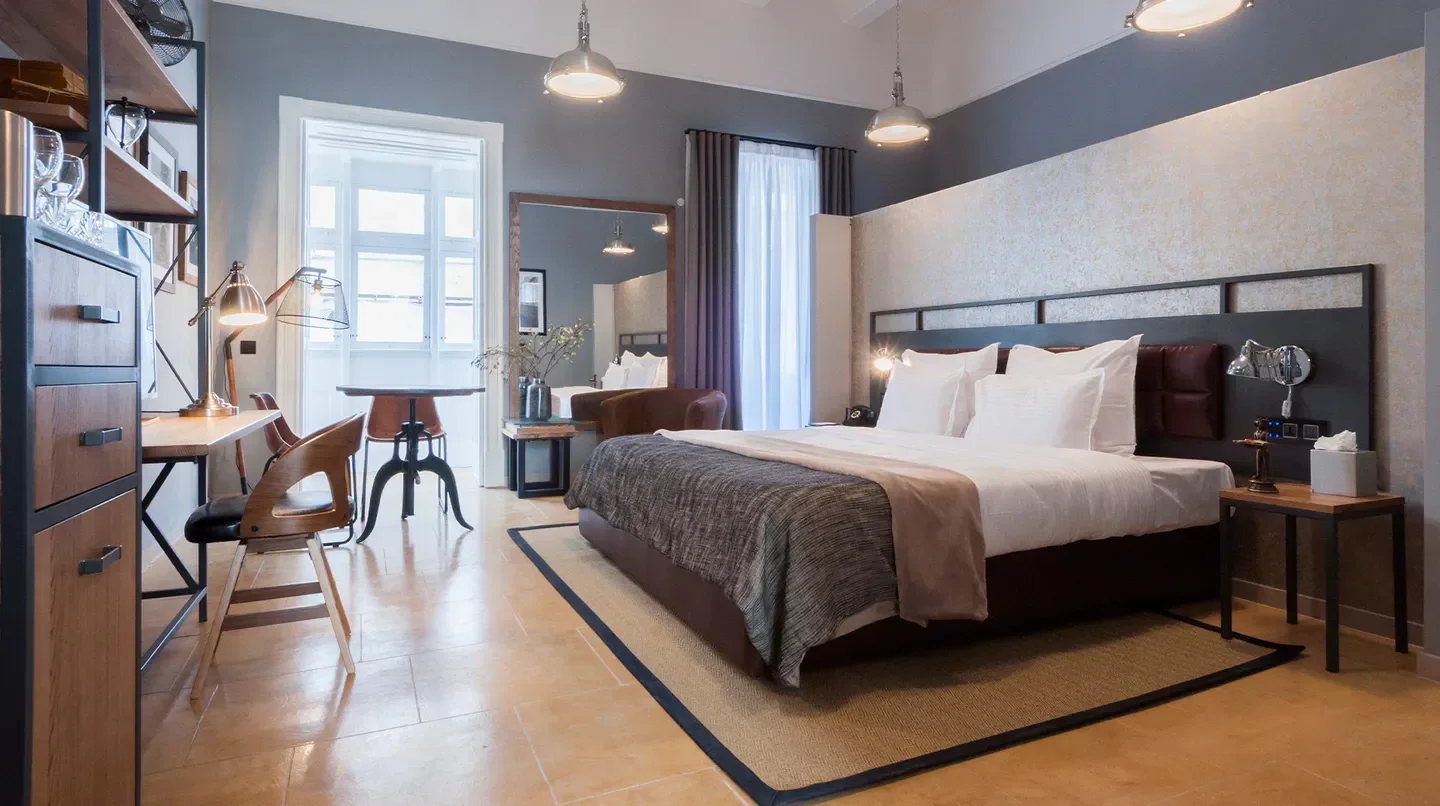 Stylish hotel room at AX The Saint John Boutique in Malta, featuring a cozy bed and workspace.