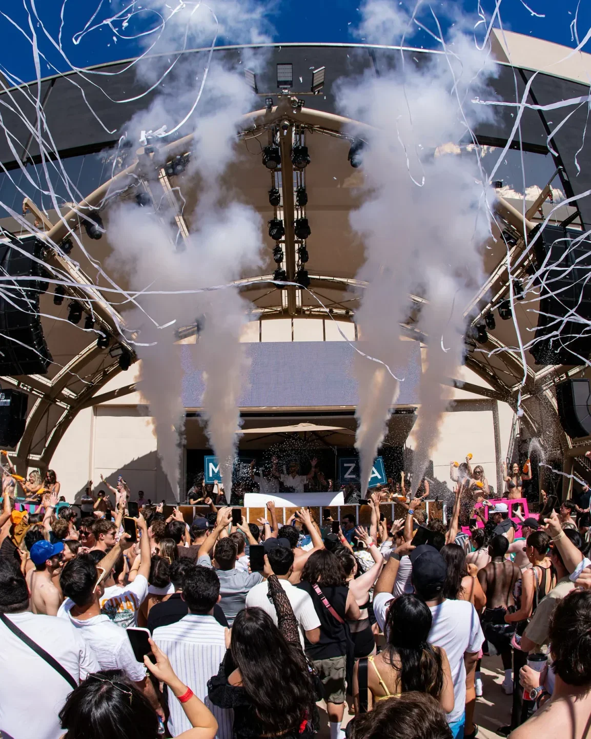 Energetic crowd at AYU Day & Night Club in Las Vegas with confetti and smoke during a concert.