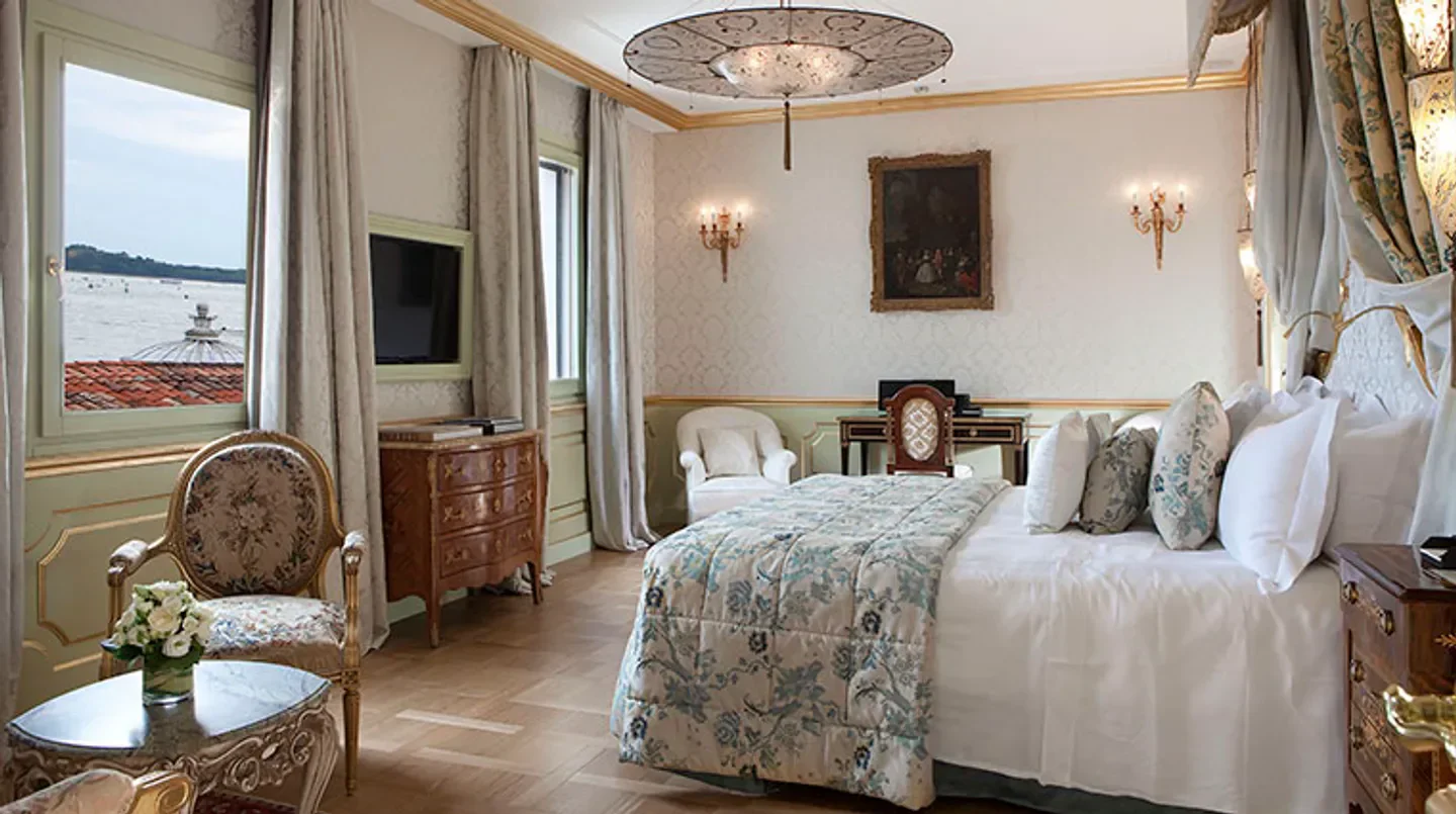Elegant bedroom at Baglioni Hotel Luna, Venice, featuring ornate decor and water views.