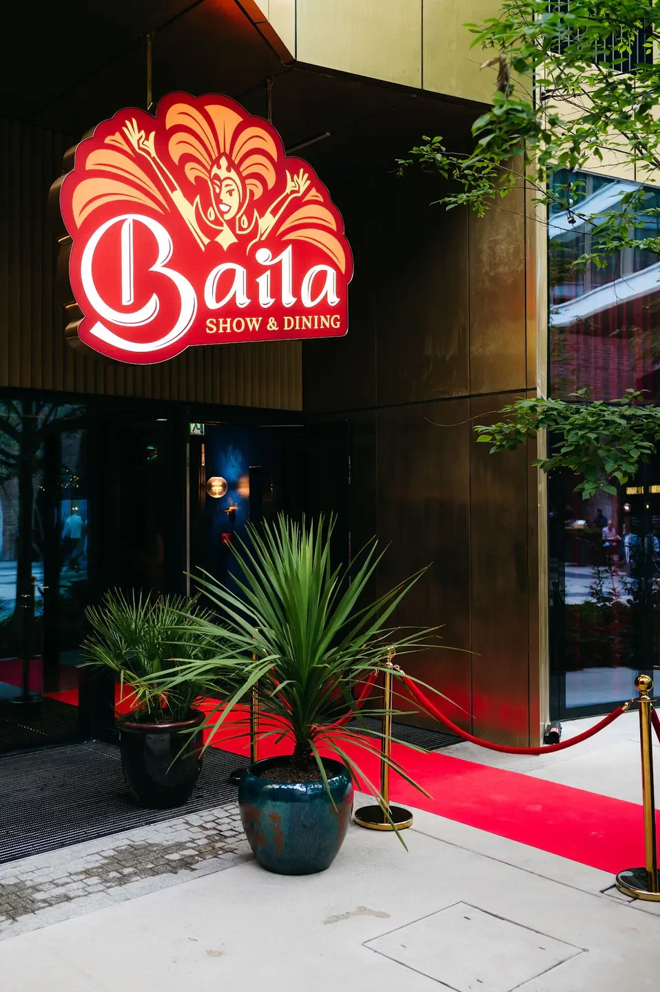 Entrance to Baila Show restaurant in Warsaw, with red carpet and a sign.