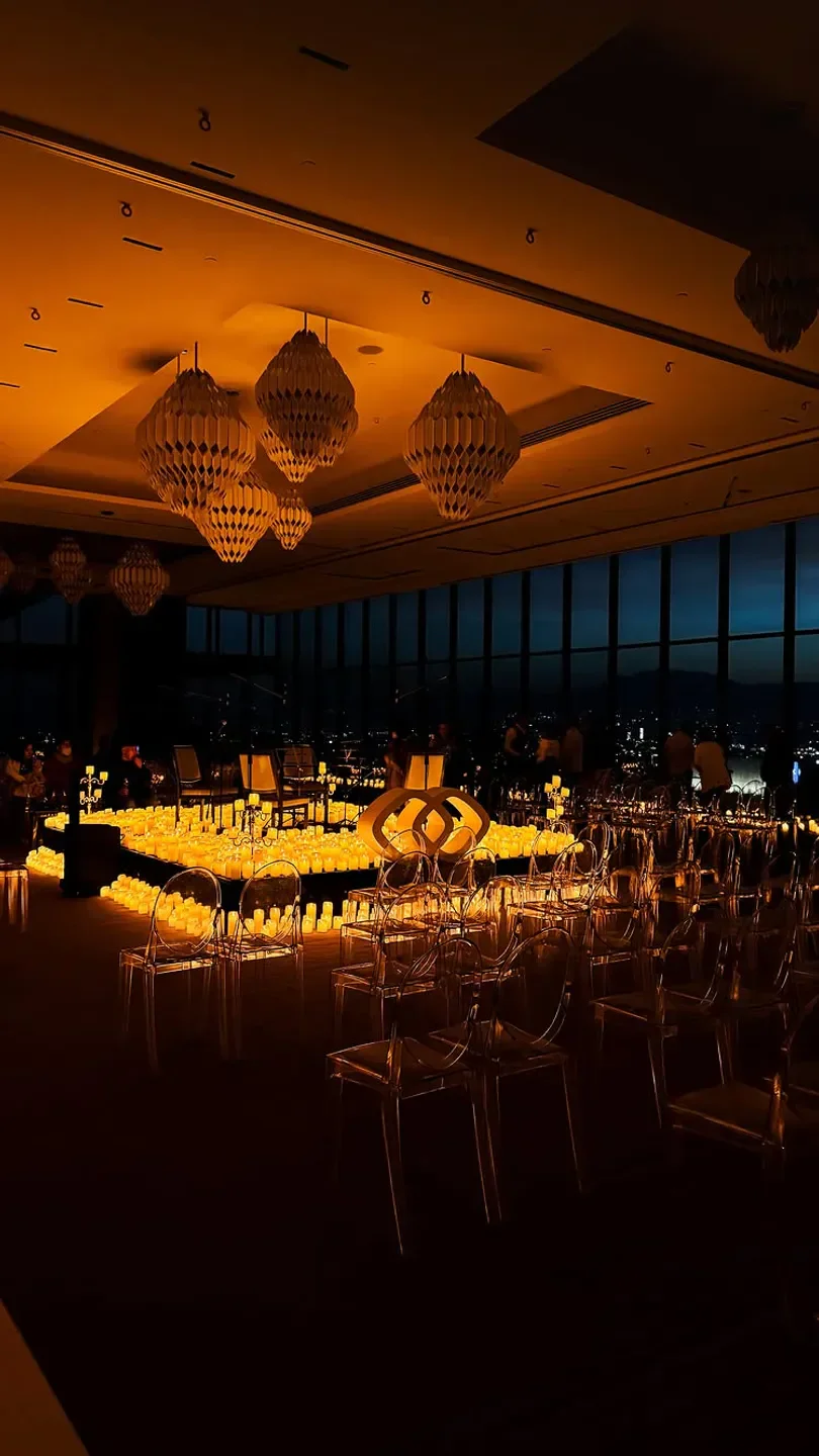 Candlelit event at BAJEL restaurant in Mexico City with city views at night.