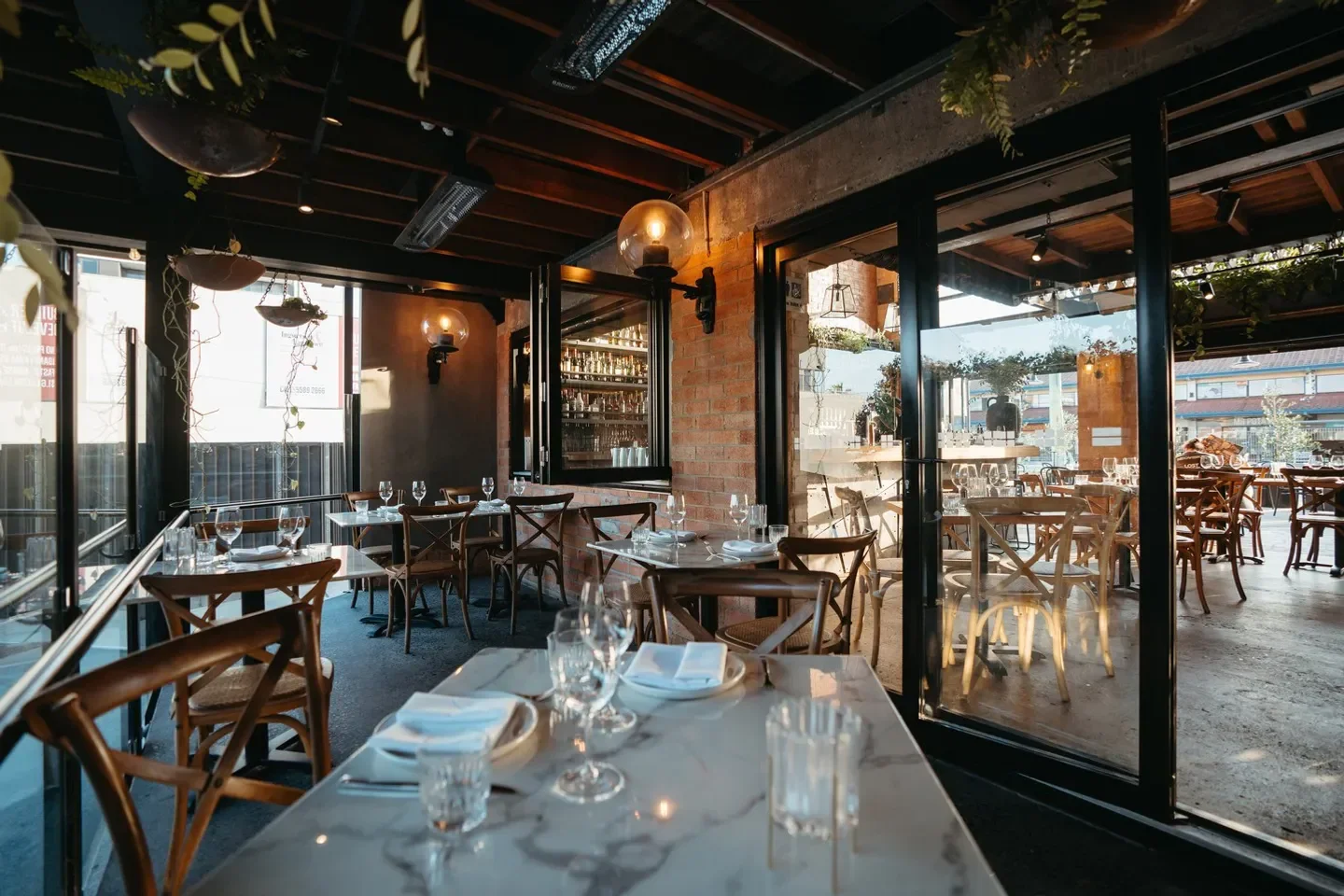 Interior dining at Balboa Italian in Gold Coast with tables and glass doors.