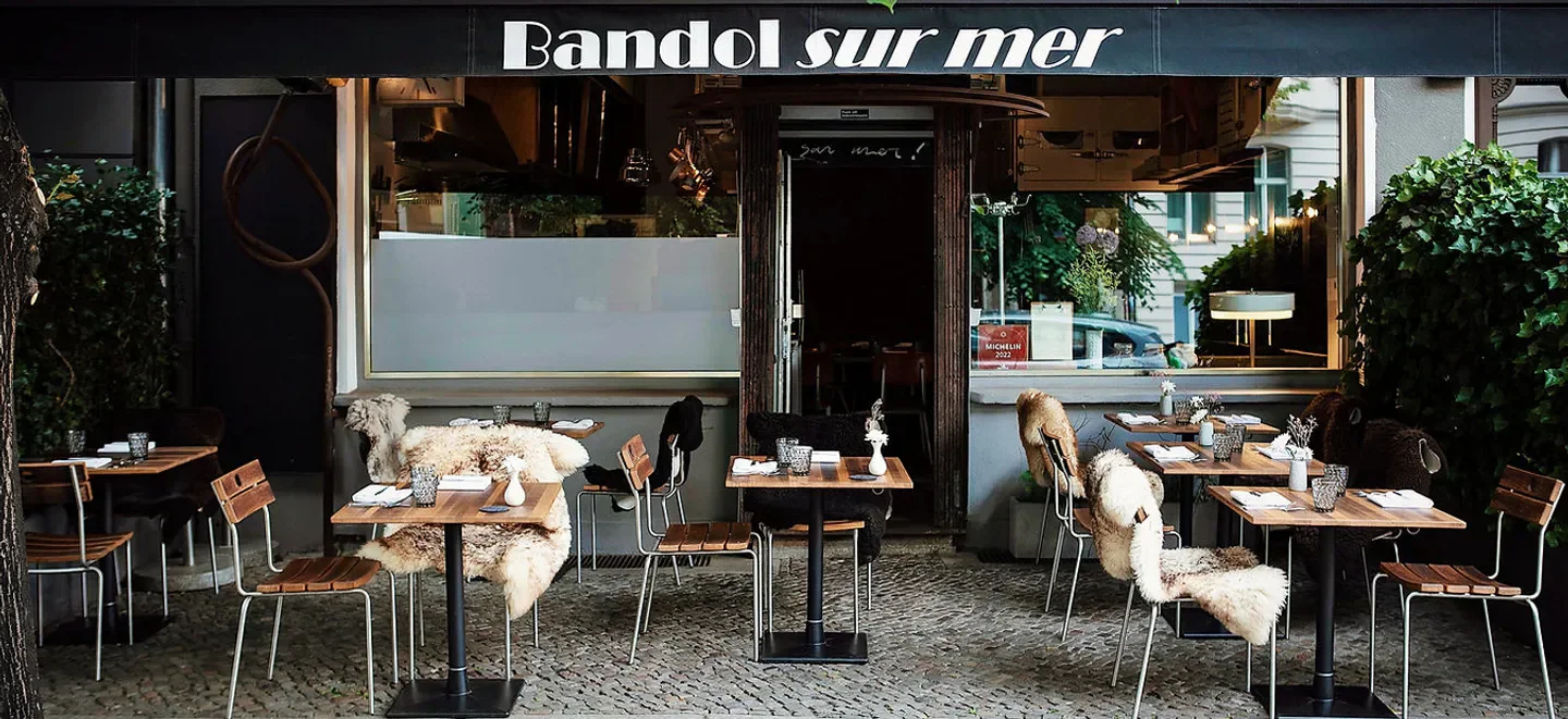Cozy outdoor seating at Bandol sur mer restaurant in Berlin, featuring sheepskin-covered chairs.