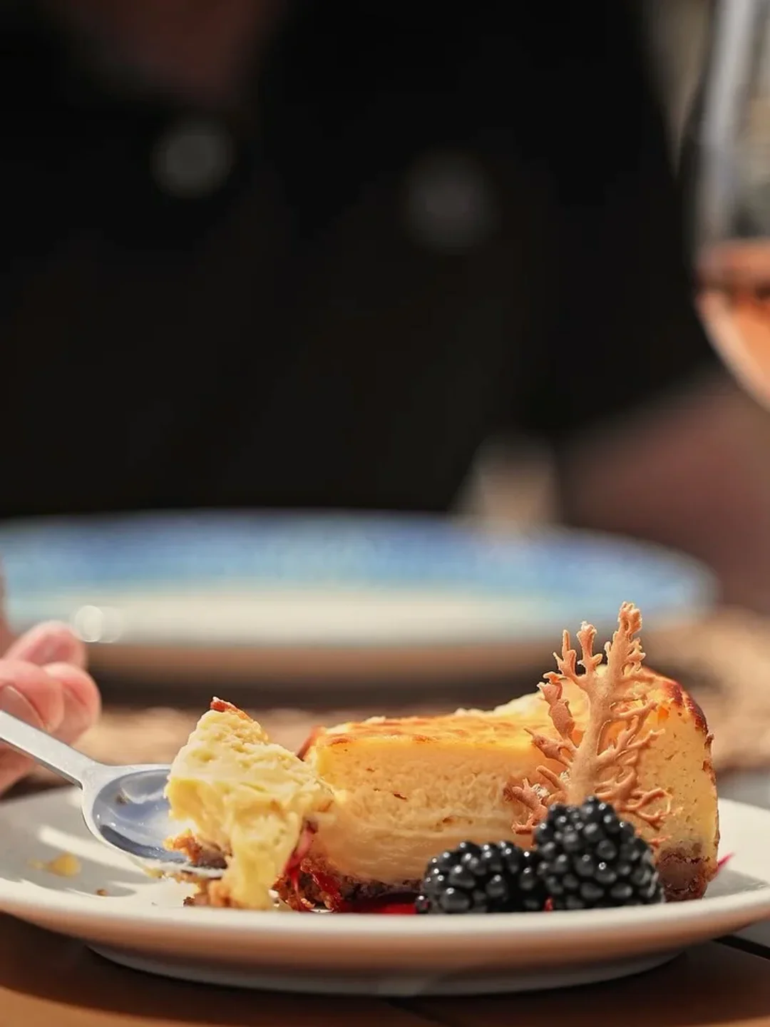 Decadent cheesecake with blackberry and coral garnish at Banus Beach restaurant.