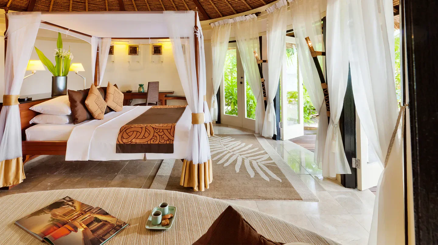 Luxury bedroom at Banyan Tree Vabbinfaru in the Maldives, featuring a canopy bed.