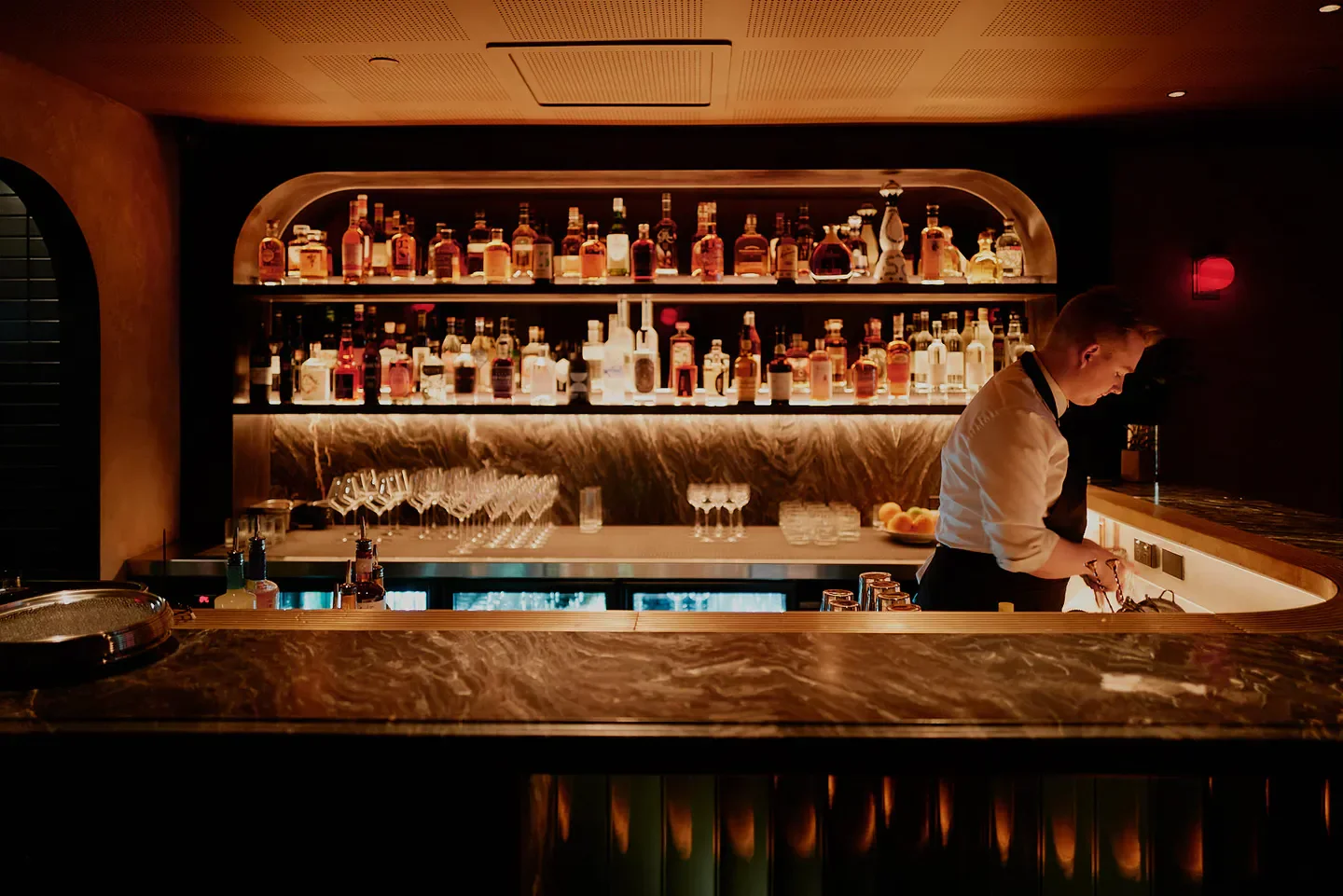 Interior of Bar Jayda in Melbourne: bartender preparing drinks with extensive liquor selection.