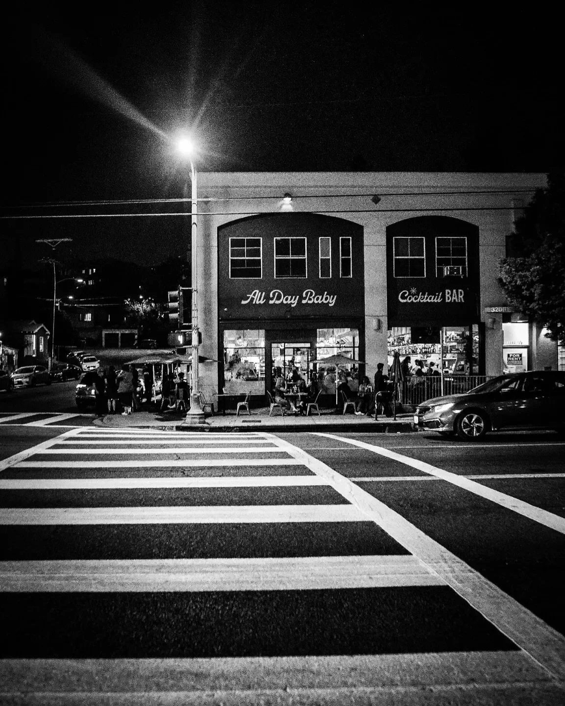 Night scene of Bar Le Côte in Santa Ynez Valley, with street and crosswalk view.