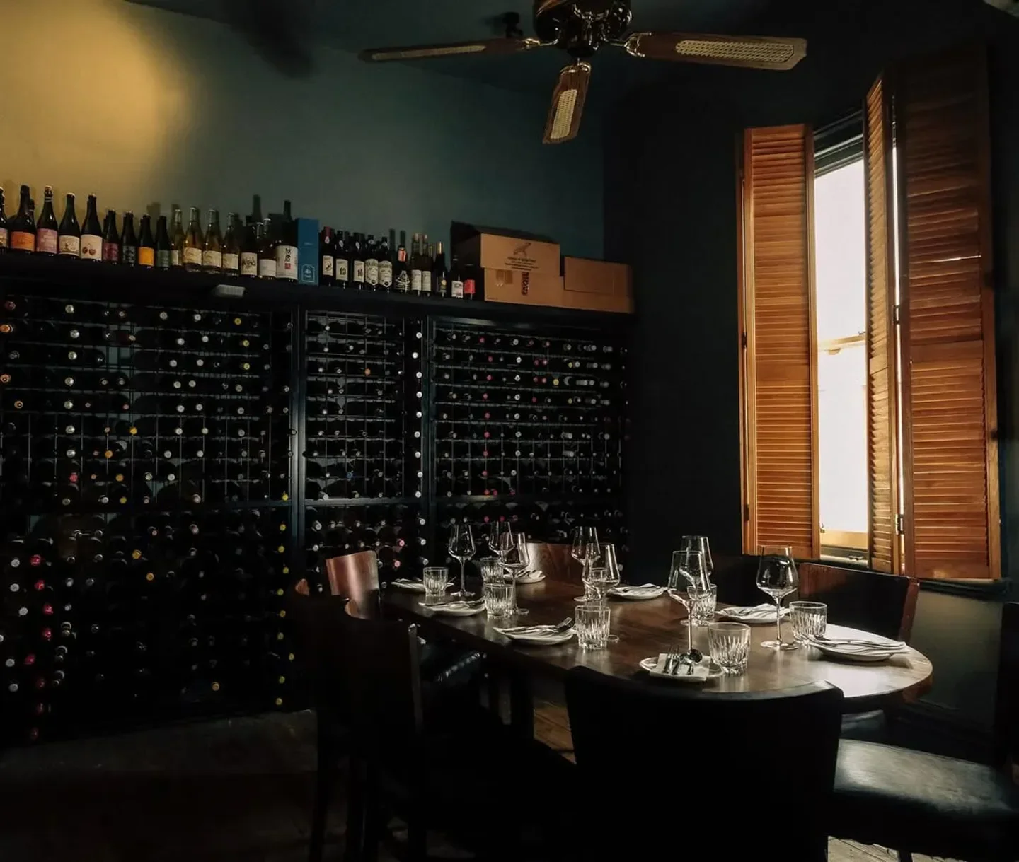 Interior of Bar Liberty restaurant in Melbourne with wine cellar and dining table.