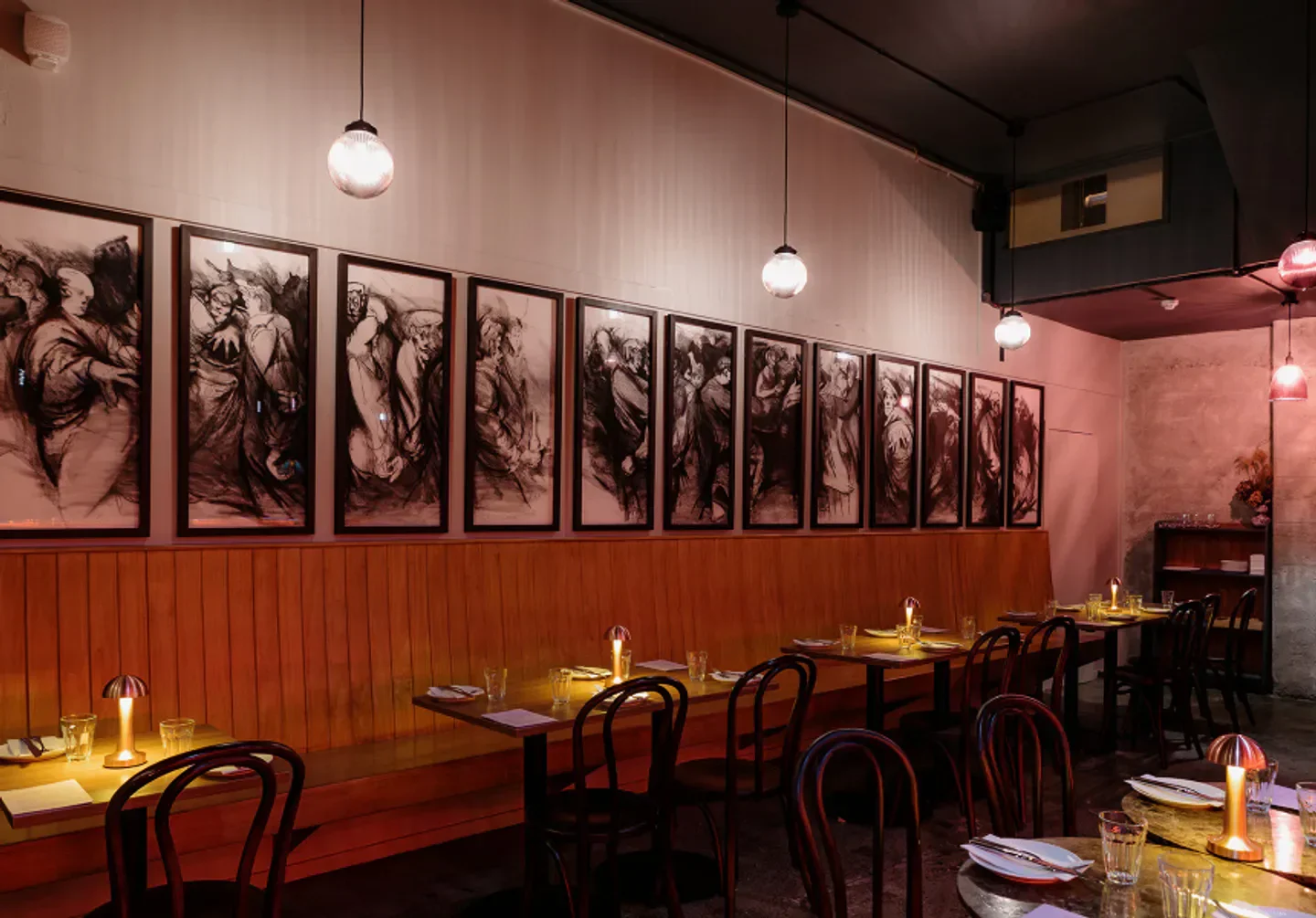 Interior of Bar Magda in Auckland, featuring art and candlelit tables.