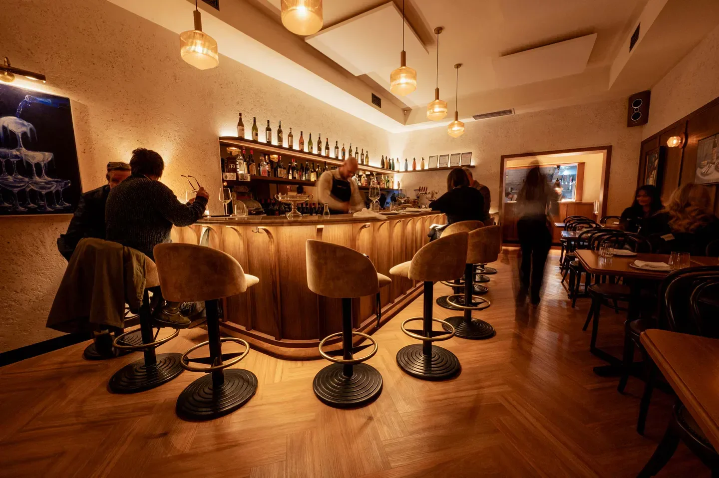 Interior of Bar Olo in Melbourne, showcasing the bar area with patrons and warm lighting.