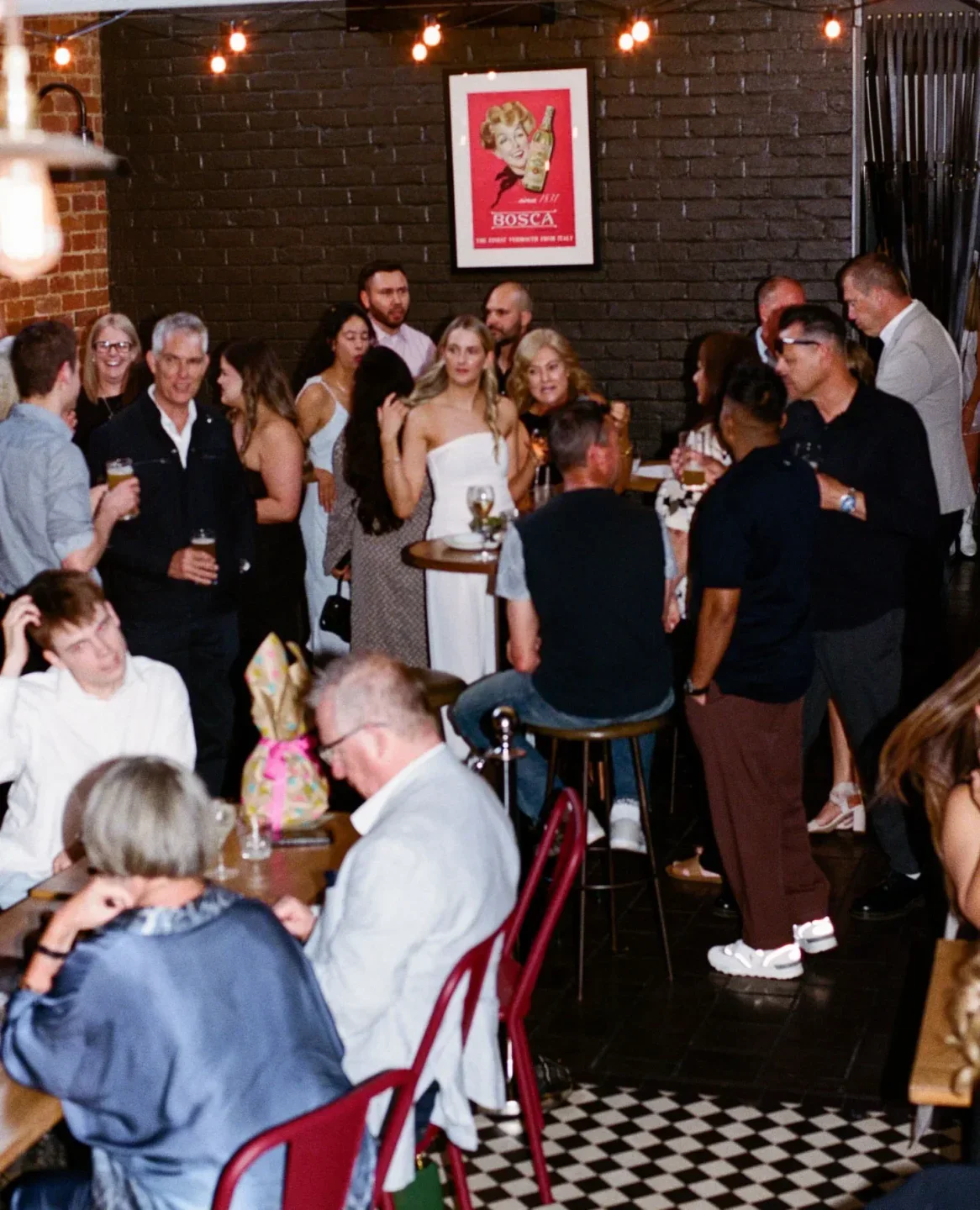 Busy crowd enjoying a night out at Bar Torino in Adelaide, featuring drinks and lively atmosphere.