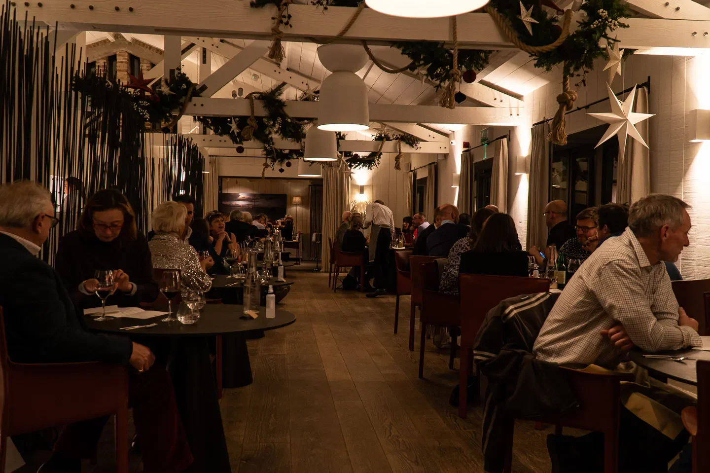 Cozy dining area at Beach House restaurant in Wales with tables and guests.