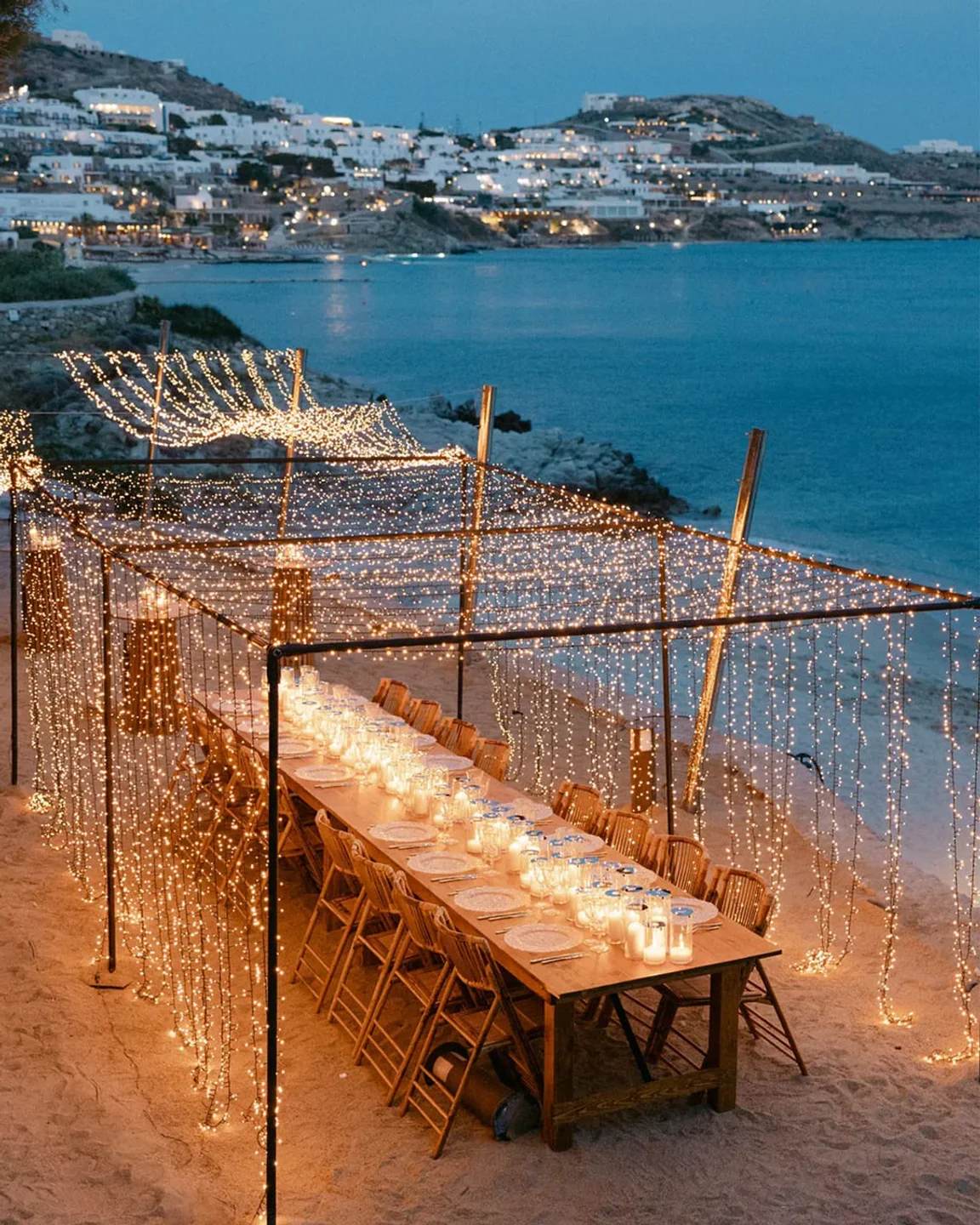 Romantic beachside dining setup at Beefbar Mykonos with string lights and sea view