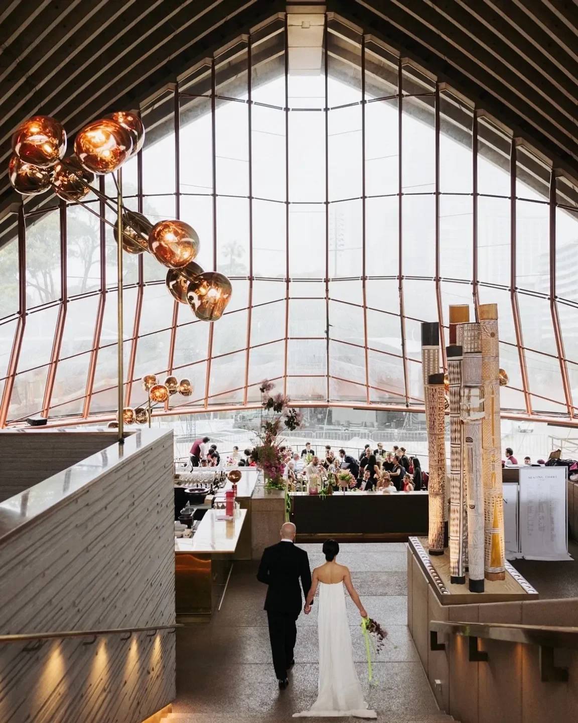 Couple walks into Bennelong restaurant in Sydney for a wedding reception.