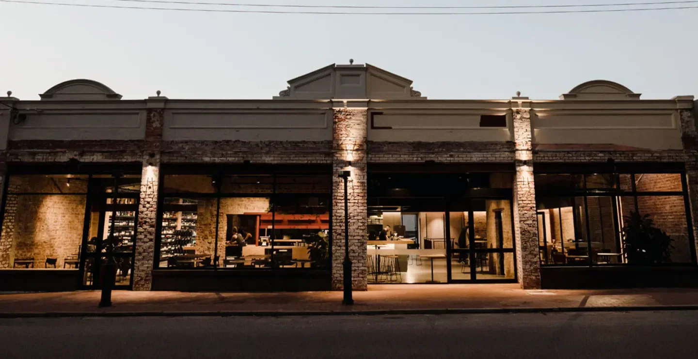 Exterior view of Besk restaurant in Perth, featuring brickwork and warm lighting.