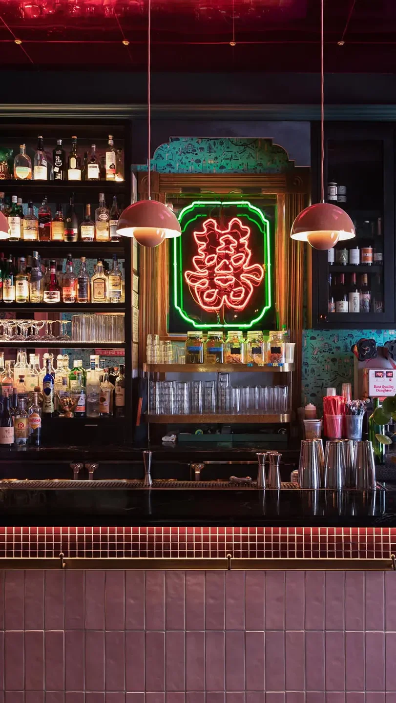 Interior bar at Best Quality Daughter in San Antonio with neon sign and drinks.