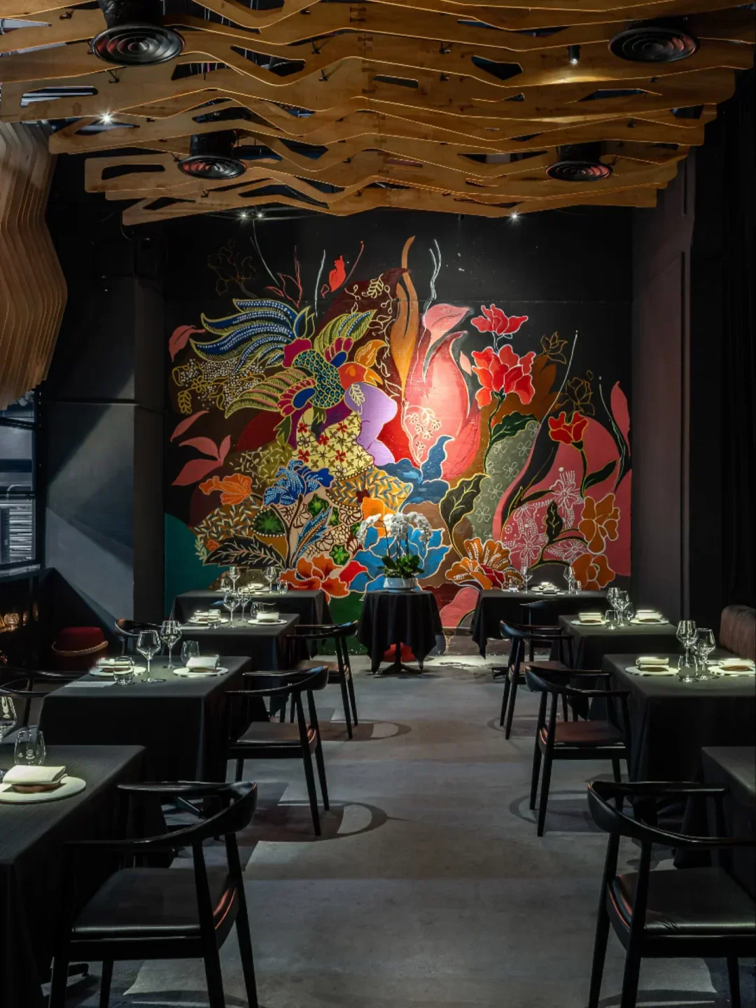 Interior of Beta restaurant in Kuala Lumpur features vibrant mural and stylish dining tables