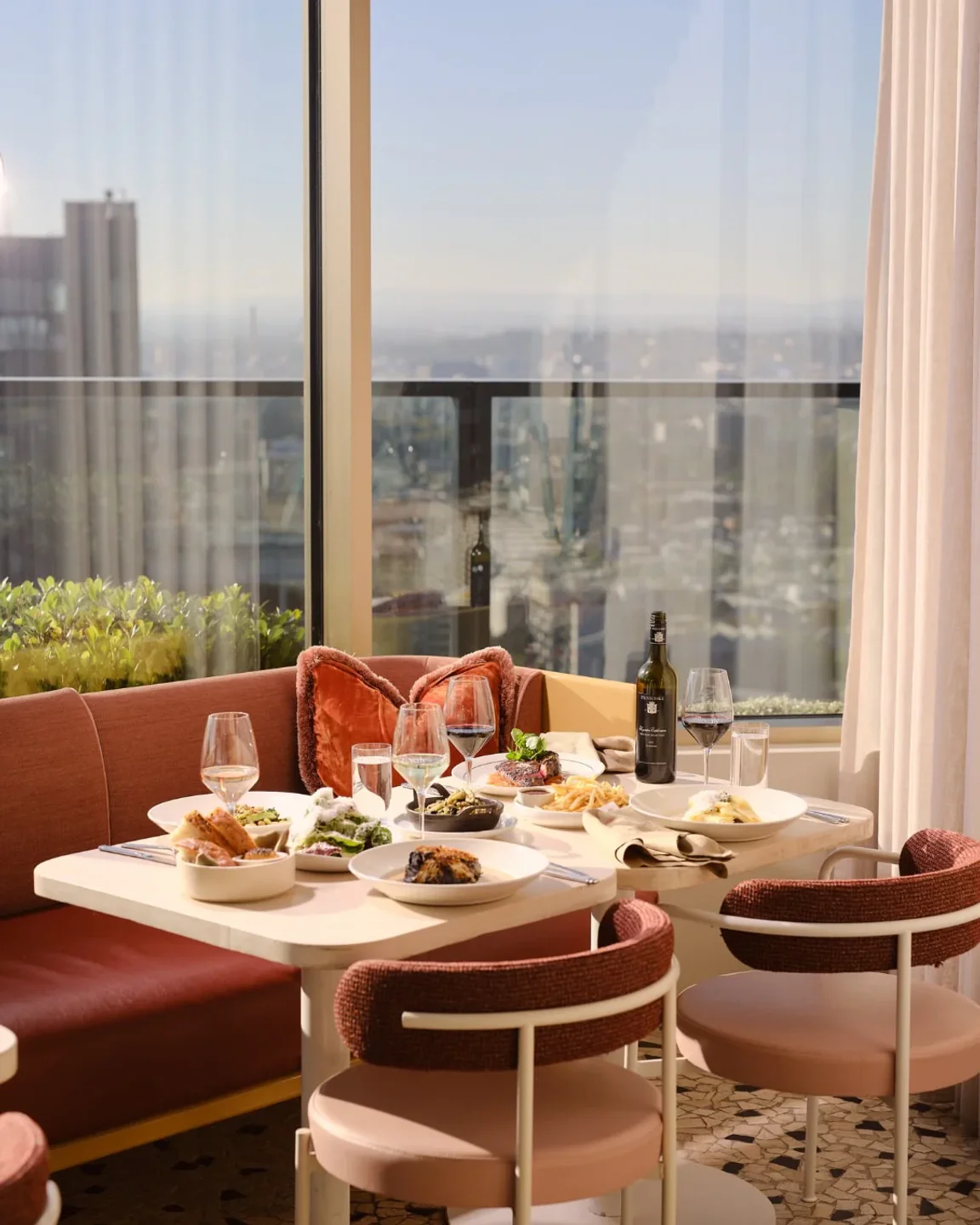 Elegant dining table set for a meal at Beverly rooftop restaurant in Melbourne, with city views.