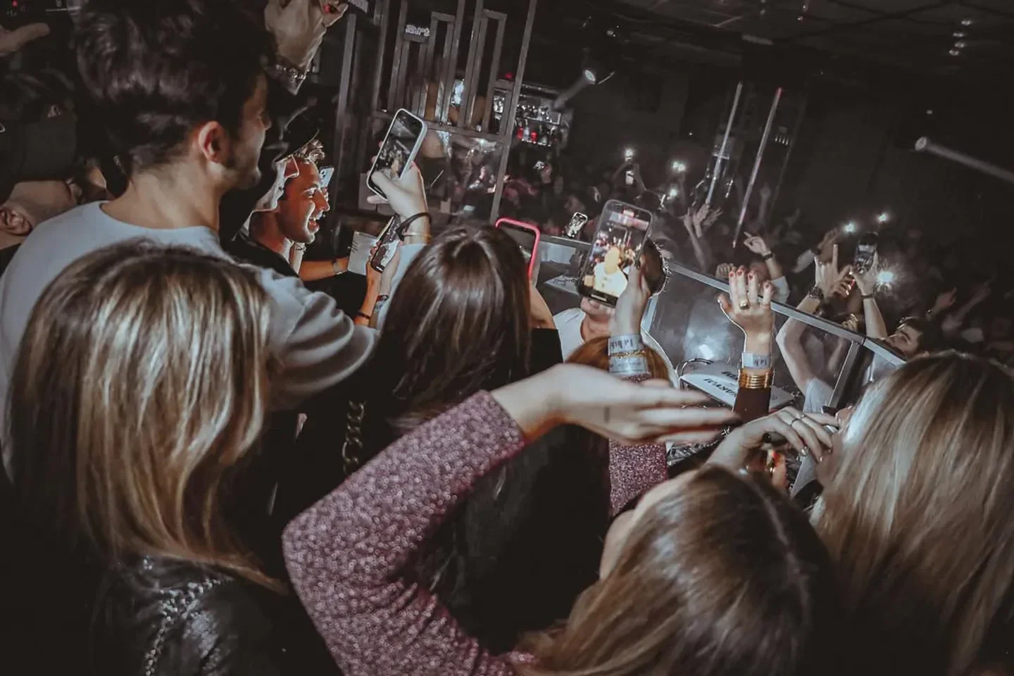 Energetic crowd at Biblio nightclub in Barcelona, capturing the moment with phones.