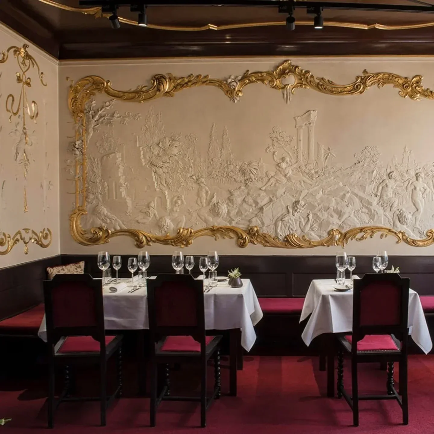 Elegant dining room at Bieberbau restaurant in Berlin, with ornate wall decor and tables