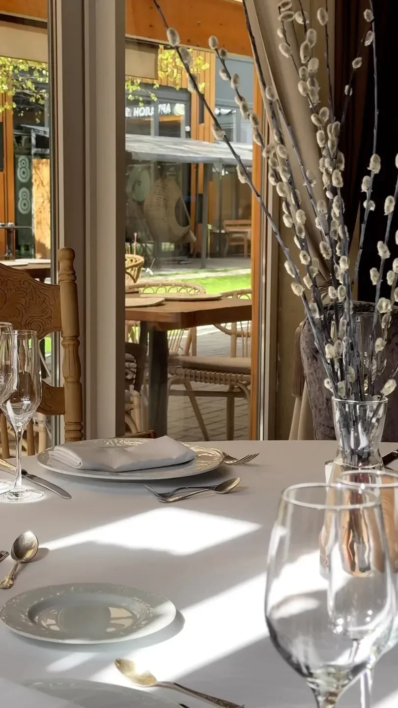 Elegant table setting at Biologie restaurant in Moscow, with outdoor seating view.