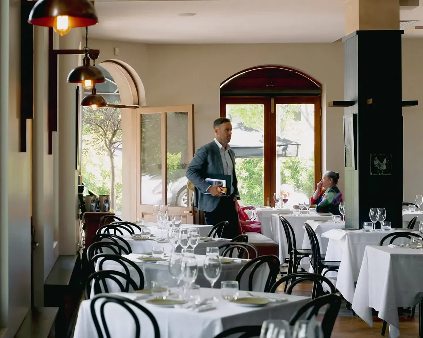 Elegant dining room at Bistro Gitan in Melbourne, featuring a well-dressed waiter and guests