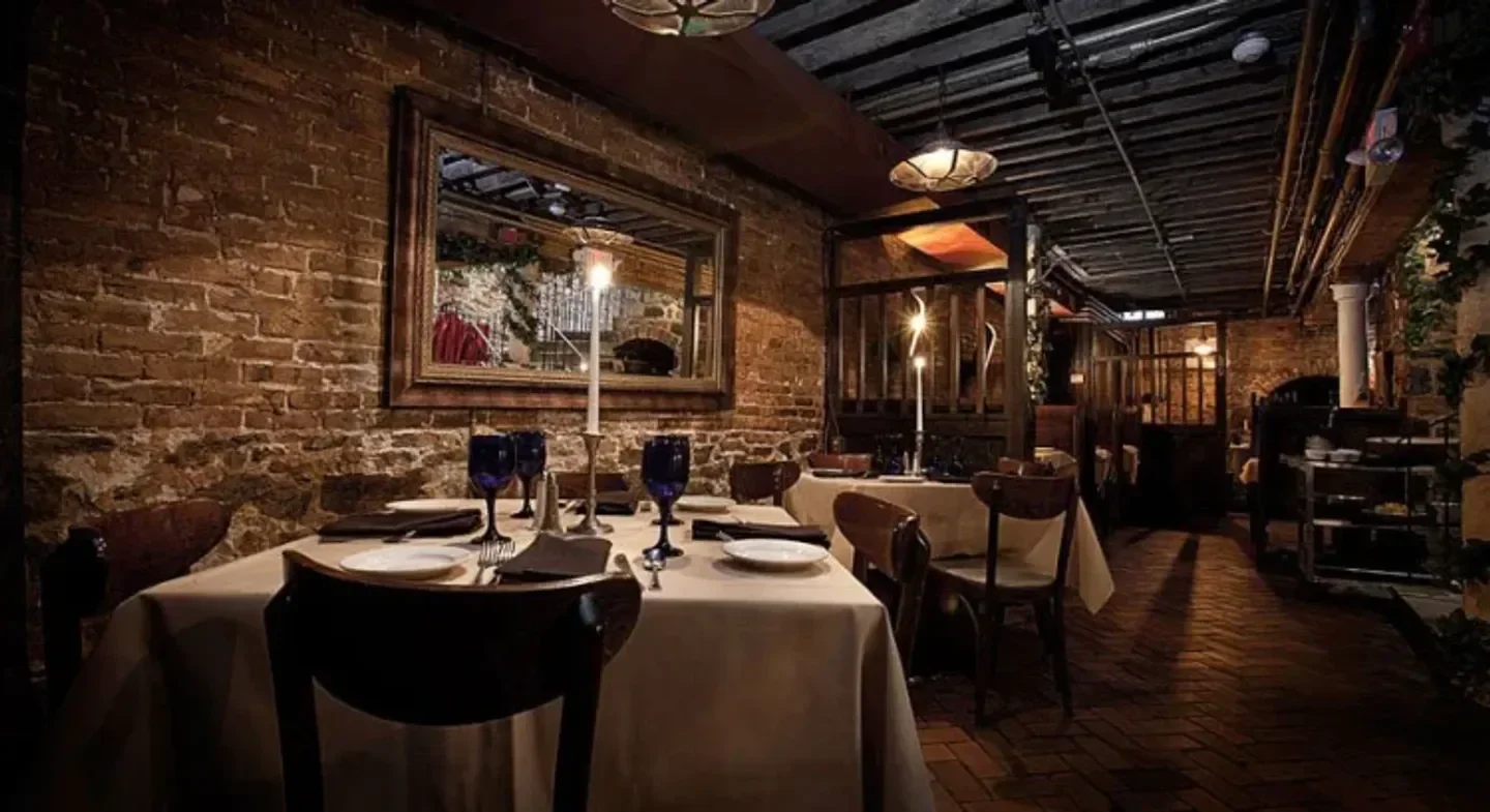 Cozy dining room interior at Bistro Romano restaurant in Philadelphia, brick walls and tables.