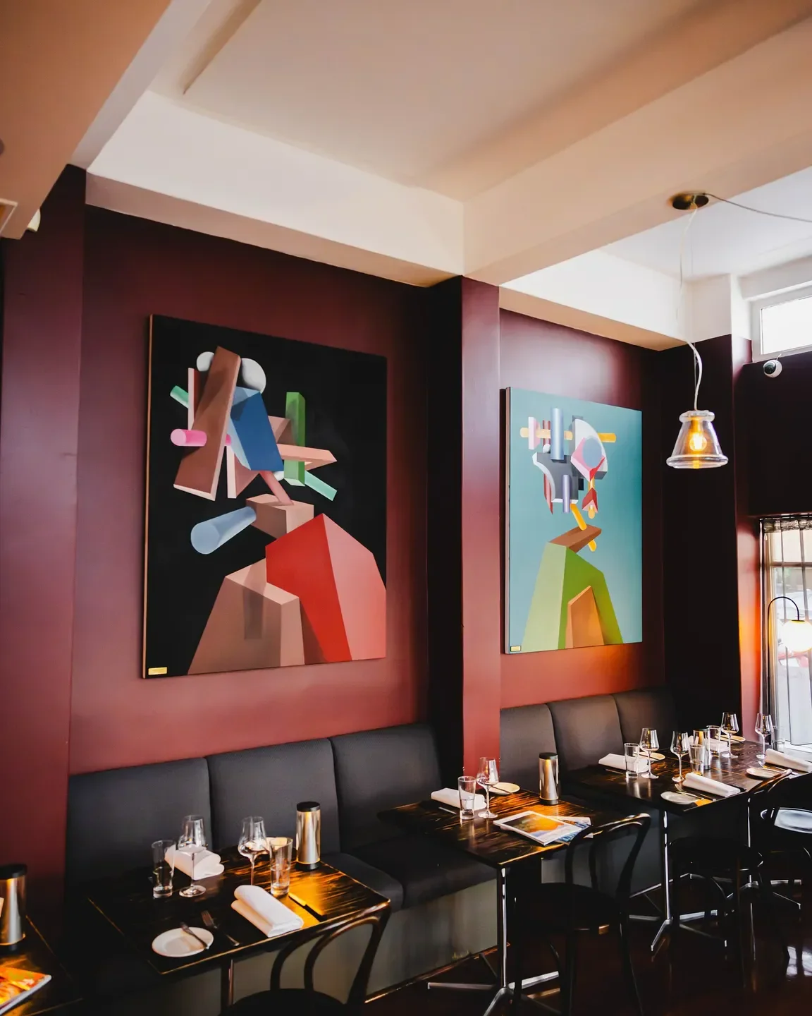 Interior of Black Cow Bistro in Launceston, featuring art and stylish dining tables.