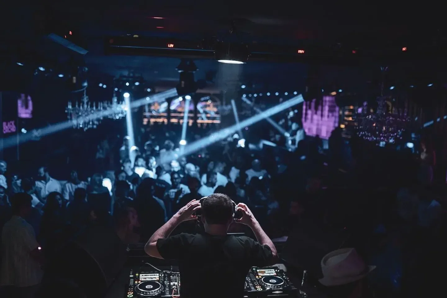 DJ at Black Orchid nightclub in Doha, with a crowd dancing under the lights.