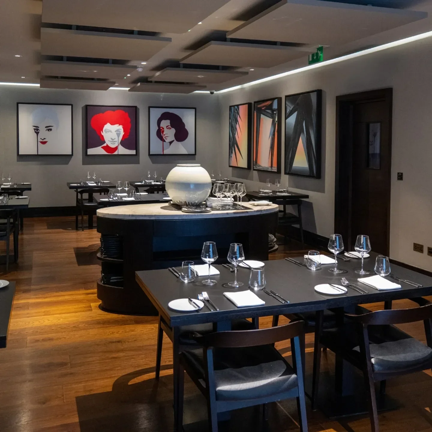 Interior of Blas Restaurant in Wales, featuring modern art and elegant dining tables.