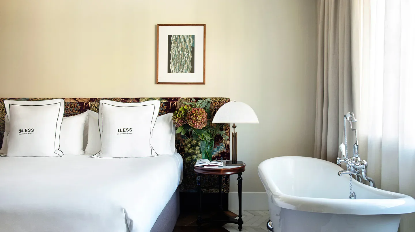 Cozy bedroom at BLESS Hotel Madrid, featuring a bathtub, offering a relaxing stay in Madrid.