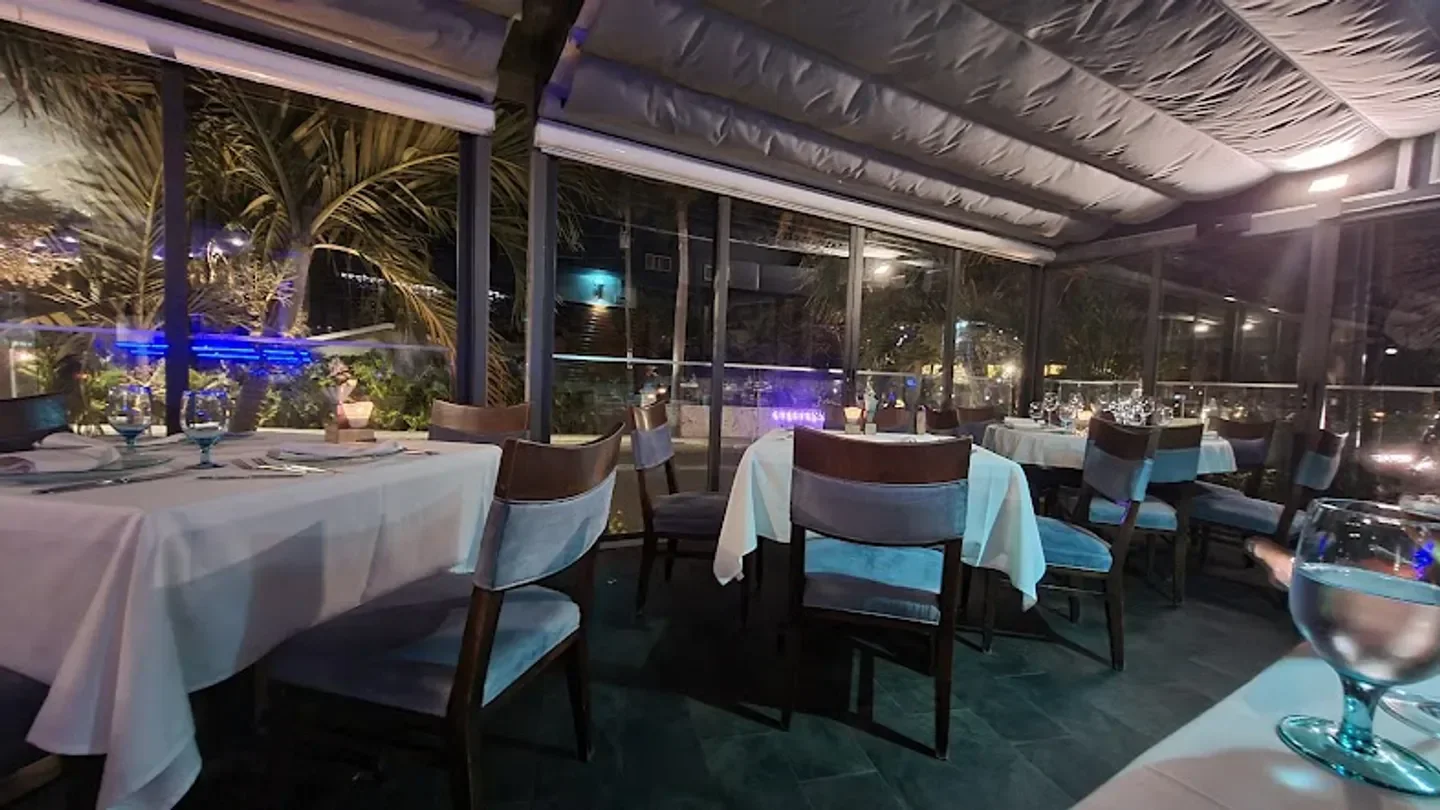 Cozy dining area at Blue Cilantro in Grand Cayman at night with outdoor views