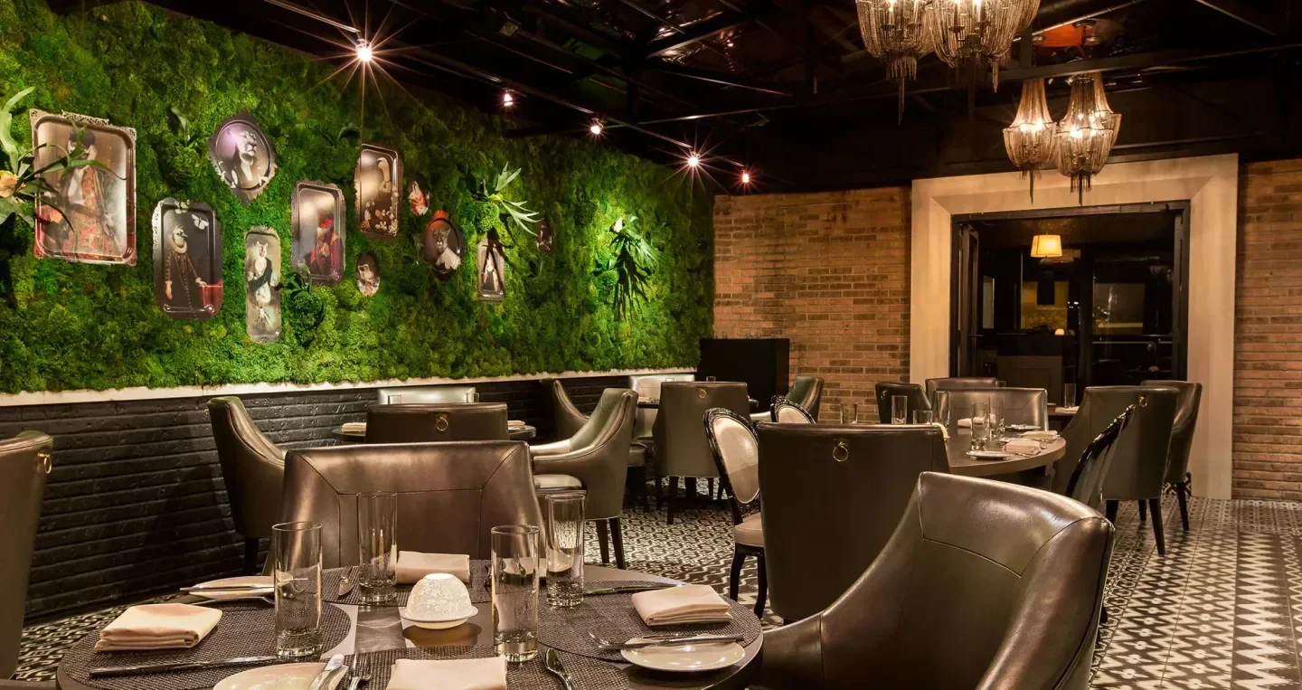 Interior of Boka in Chicago featuring a stylish moss wall and elegant dining space.