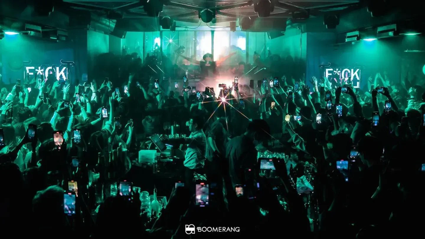 Energetic crowd at Boomerang nightclub in Hong Kong, capturing the moment with phones.