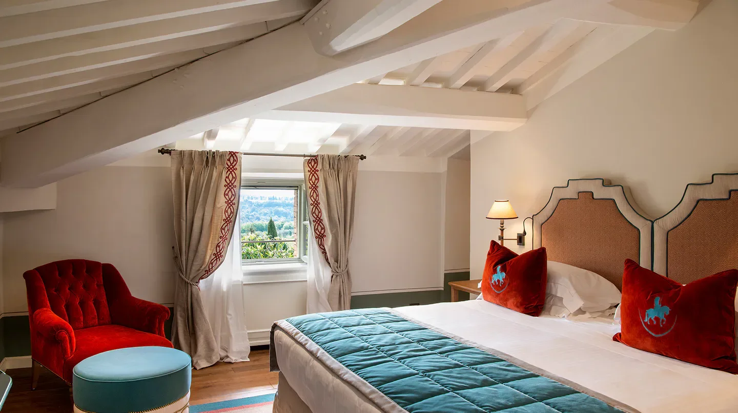 Cozy bedroom at Borgo San Felice, Florence hotel, with a view of the Tuscan countryside