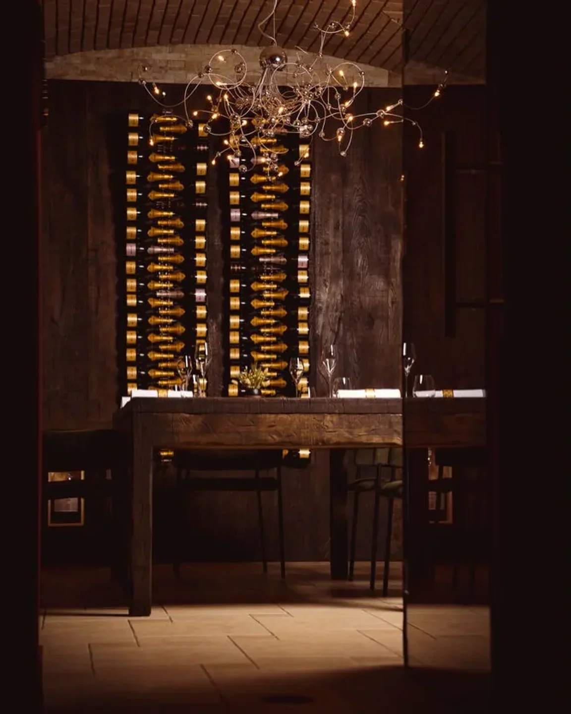 Interior of Bottiglieria 1881 in Krakow: elegant dining table with wine cellar background.