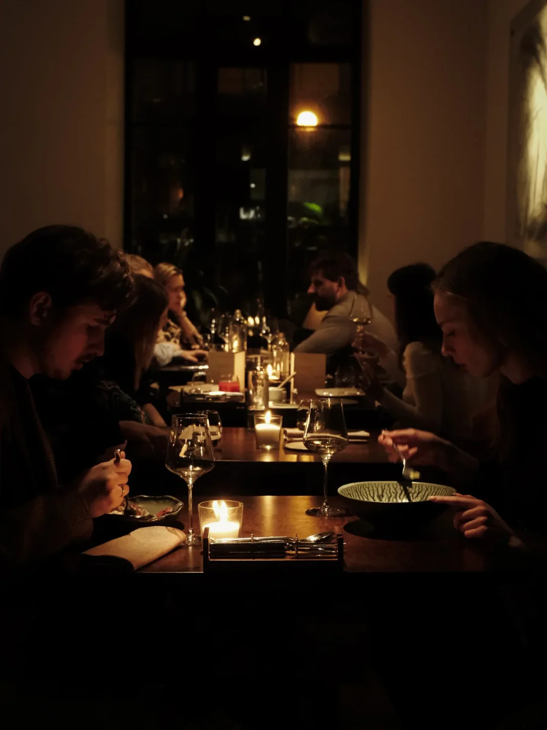 Cozy dining at Bourgeois Bohemians restaurant in St Petersburg, Russia. Candlelit dinner with friends, enjoying a meal.