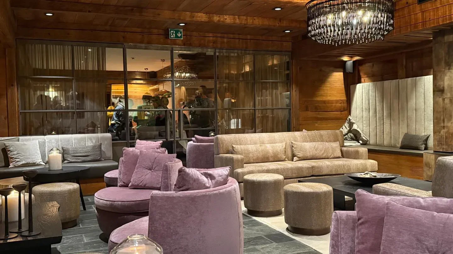 Cozy seating area at Brasserie Restaurant Esprit Bernerhof in Gstaad, featuring chandeliers and decor.