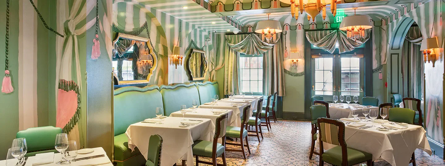 Brennan's in New Orleans: Elegant dining room with colorful, striped decor and tables set.