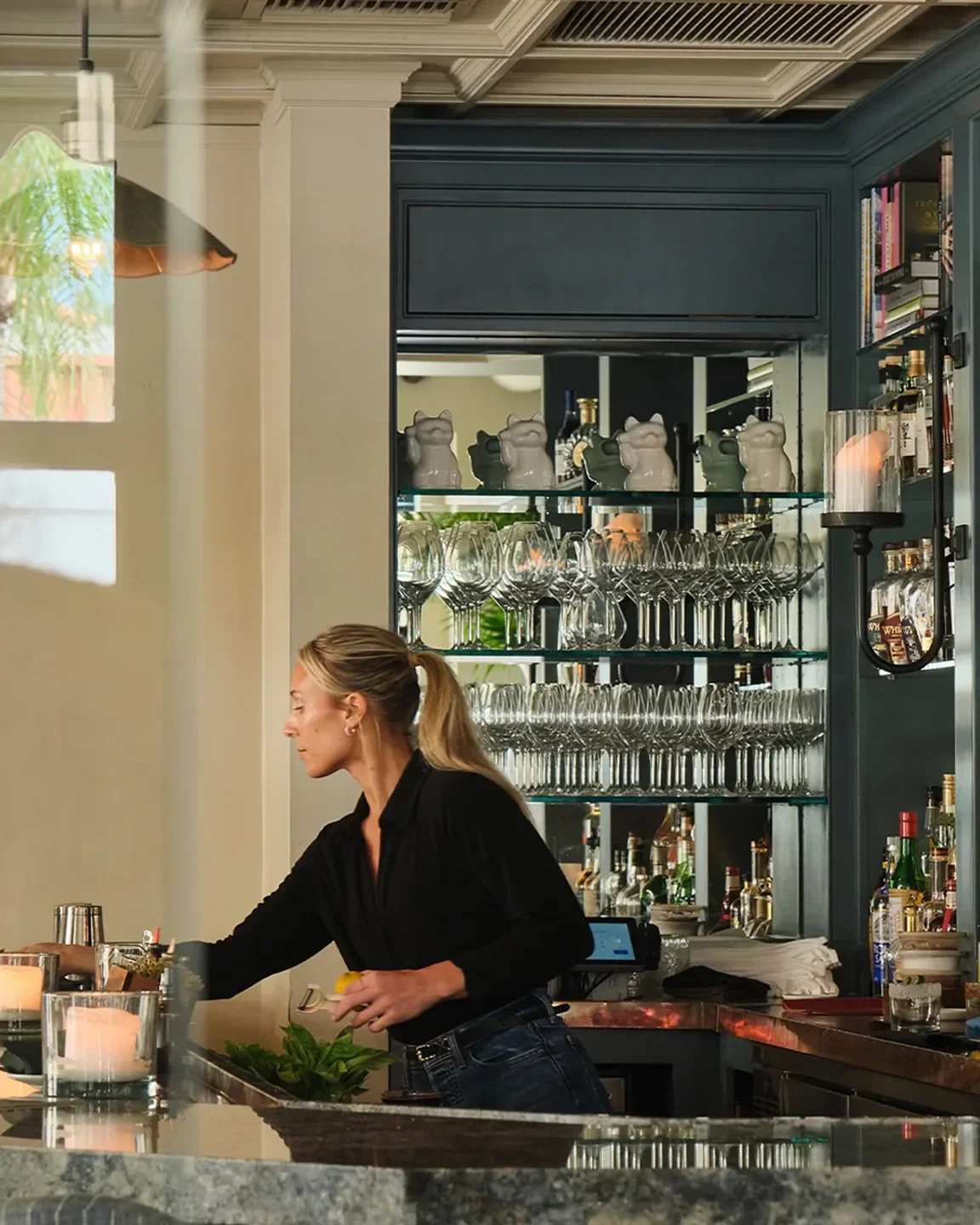 Interior of Buccan restaurant in Palm Beach, a bartender preparing a drink.