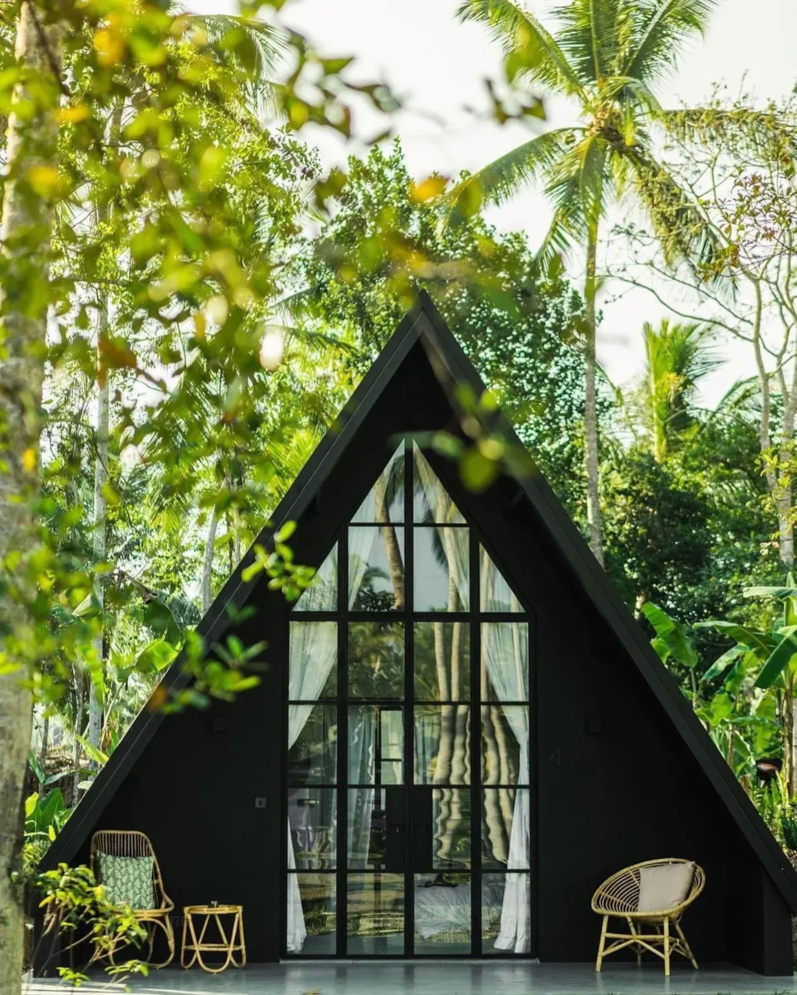 Black triangular building in lush setting at Bukhara restaurant, New Delhi, India