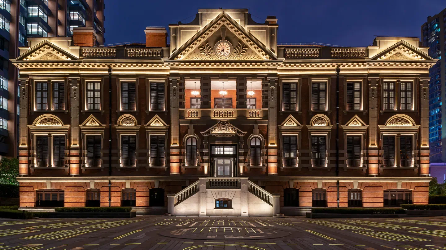 Exterior of the Bvlgari Hotel Shanghai at night, showcasing architectural details.