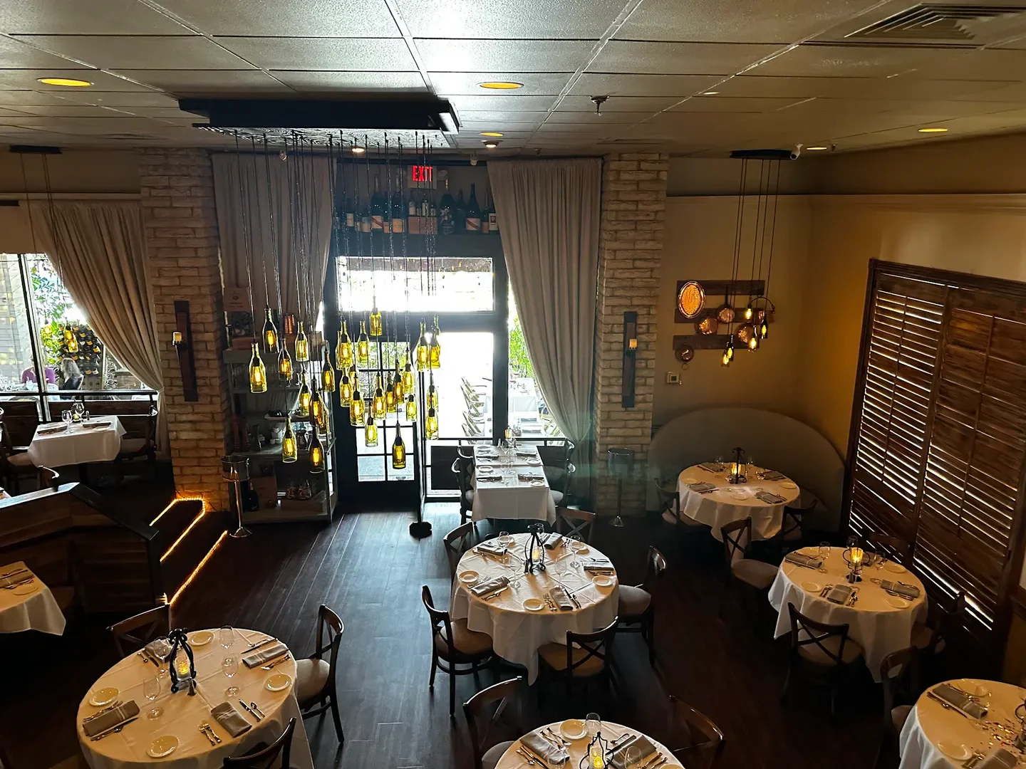 Elegant dining room interior at Café Chardonnay in Palm Beach with bottle lights.