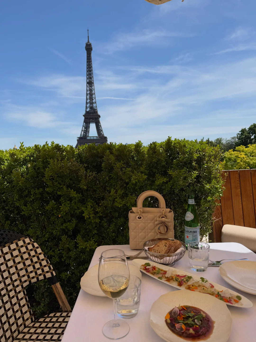 Chic table setting at Café de l'Homme with Eiffel Tower view in Paris, featuring gourmet dishes and wine.